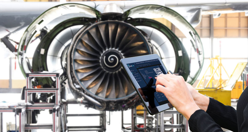 A personn is holding a tablet with toolLive app in an engien shop